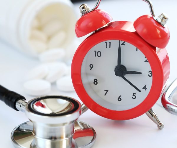 stethoscope-alarm-clock-white-pills-closeup-healthcare-min